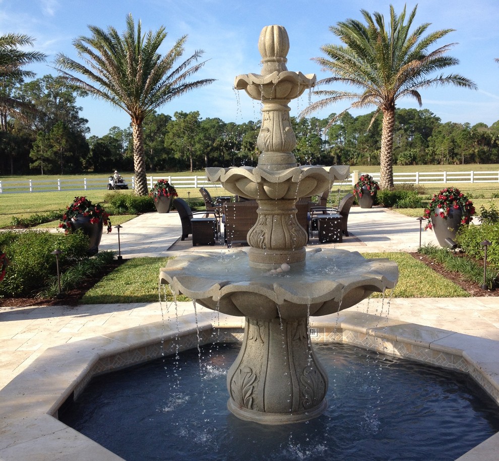 Photo of a huge mediterranean full sun backyard stone water fountain landscape in Other.