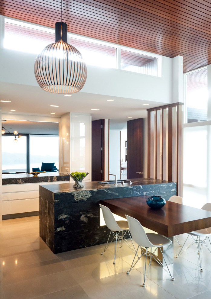 Mid-sized contemporary open plan kitchen in Auckland with flat-panel cabinets, white cabinets, an undermount sink, granite benchtops, porcelain floors and multiple islands.