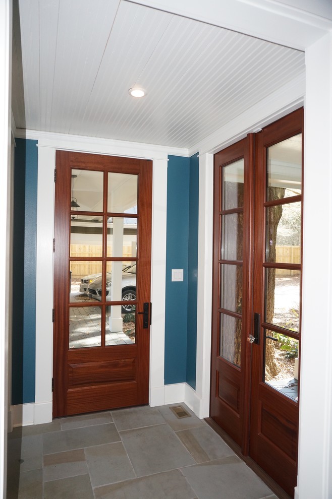 Design ideas for a large traditional front door in Miami with blue walls, concrete floors, a double front door and a medium wood front door.