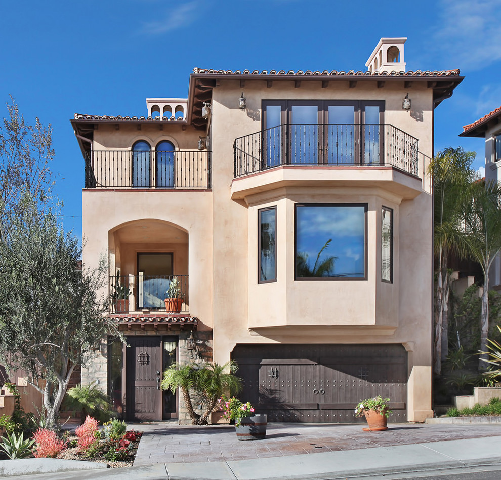This is an example of a mediterranean three-storey beige exterior in Orange County.