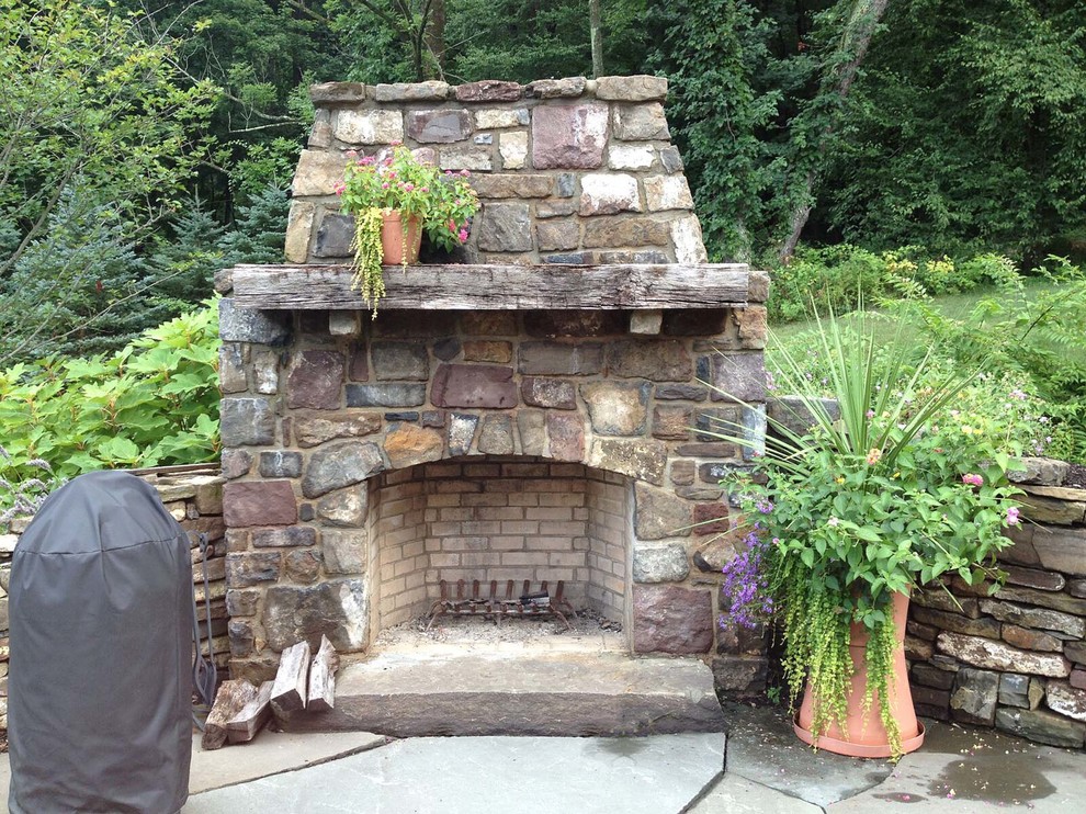 This is an example of a country backyard patio in Philadelphia with natural stone pavers.