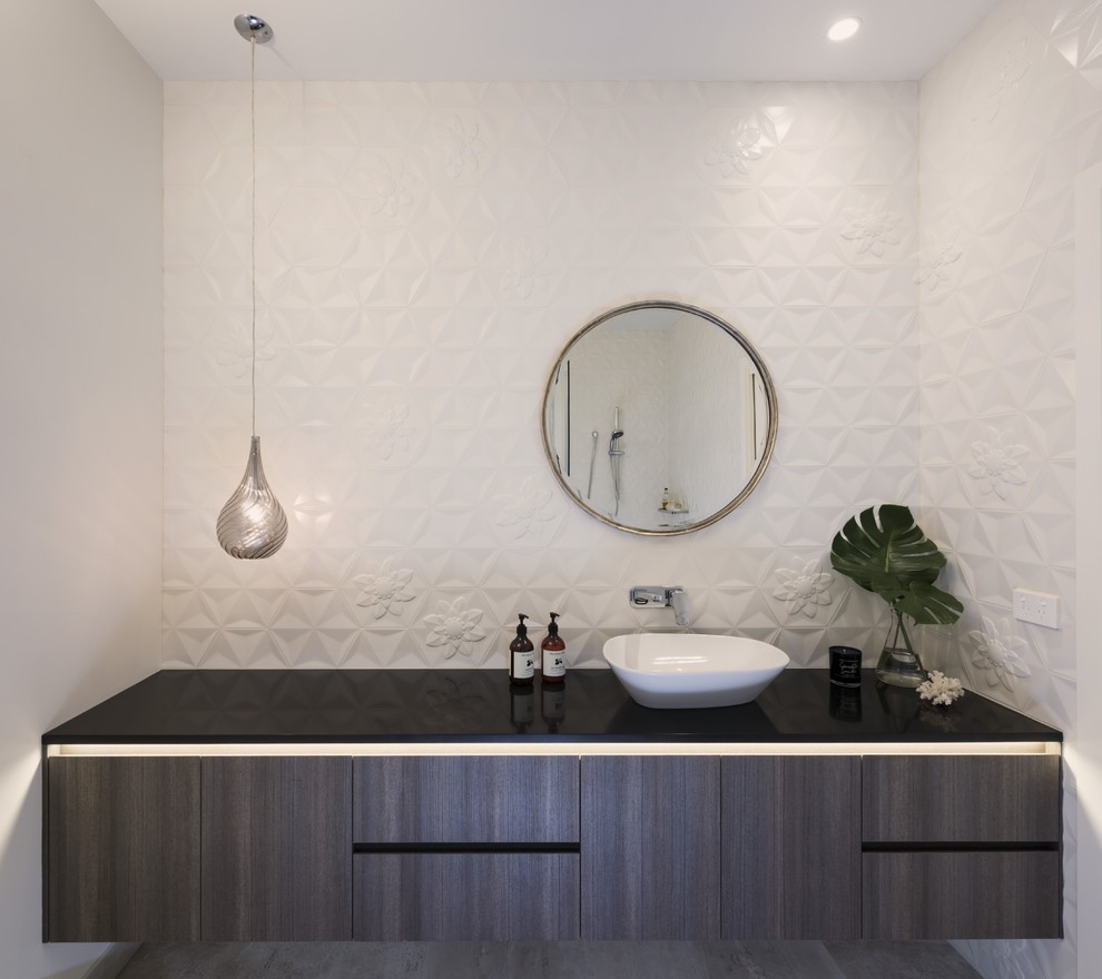 Trendy white tile and porcelain tile porcelain tile and brown floor bathroom photo in Melbourne with flat-panel cabinets, dark wood cabinets, white walls, quartz countertops, black countertops and a vessel sink