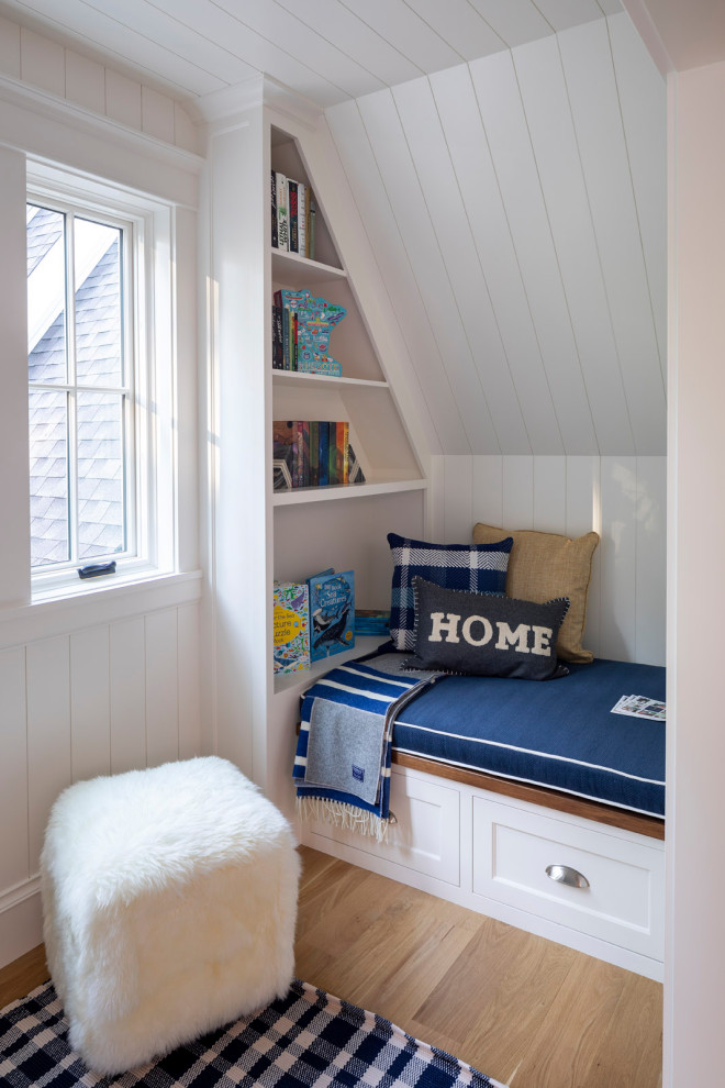 Imagen de habitación infantil unisex costera pequeña con escritorio, paredes blancas, suelo de madera clara, machihembrado y machihembrado