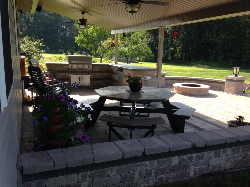 Design ideas for a large arts and crafts backyard patio in Cleveland with an outdoor kitchen, brick pavers and a roof extension.