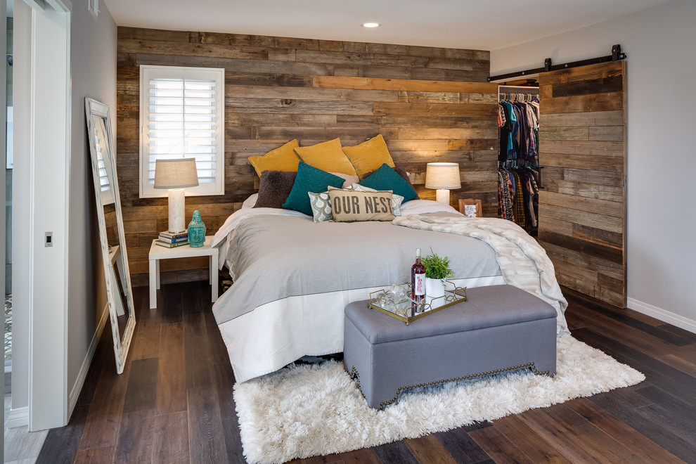 This is an example of a country master bedroom in San Diego with white walls and dark hardwood floors.