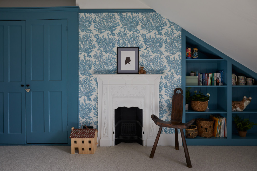 Gästezimmer mit blauer Wandfarbe, Teppichboden, Kamin, Kaminumrandung aus Metall, beigem Boden und Tapetenwänden in London