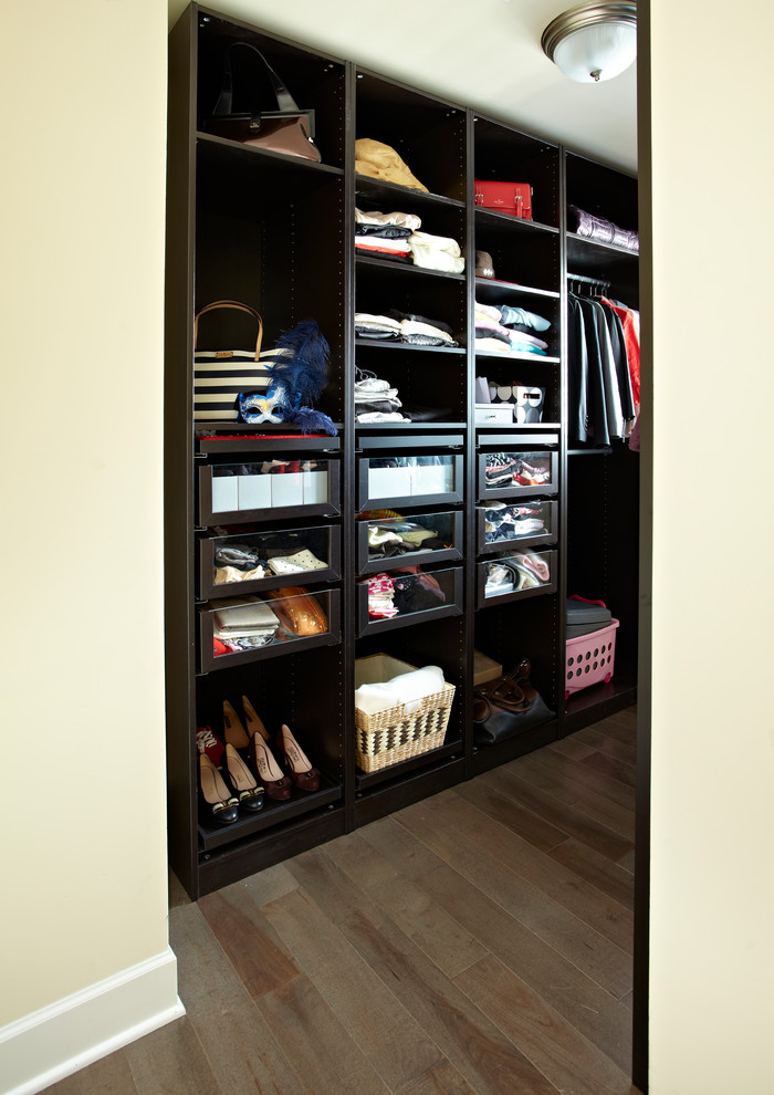 Inspiration for a large traditional gender-neutral walk-in wardrobe in New York with dark wood cabinets and medium hardwood floors.