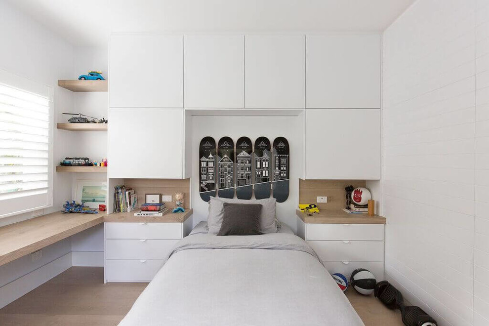This is an example of a contemporary gender-neutral kids' room in Sydney with white walls, light hardwood floors and beige floor.