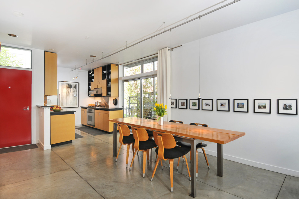 Modern dining room in Seattle with concrete floors.