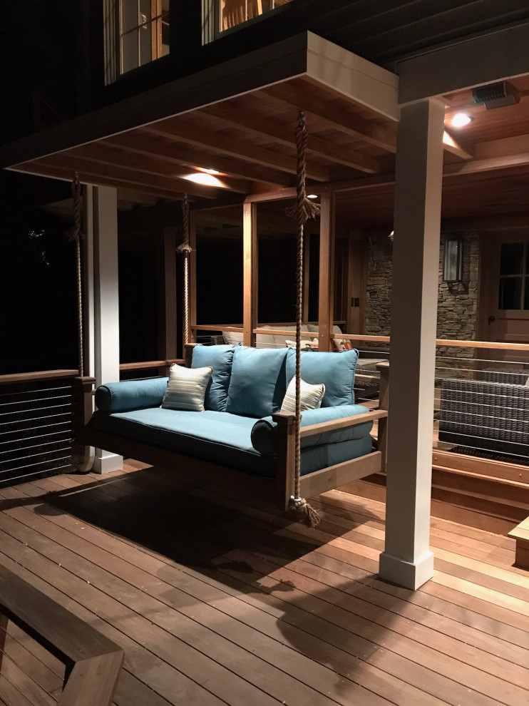 Deck - huge transitional backyard ground level cable railing deck idea with a roof extension