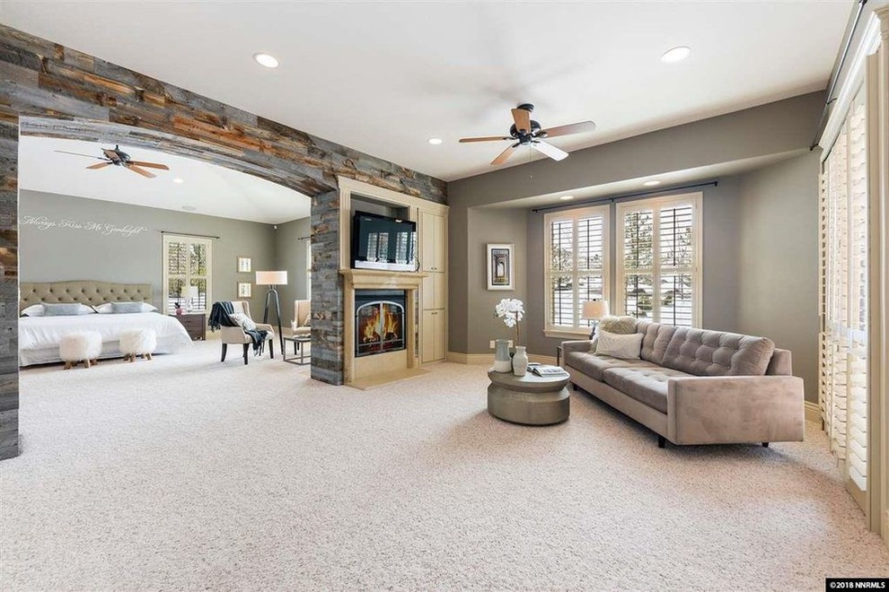 Large transitional master bedroom in Other with grey walls, carpet, a two-sided fireplace, a wood fireplace surround and multi-coloured floor.