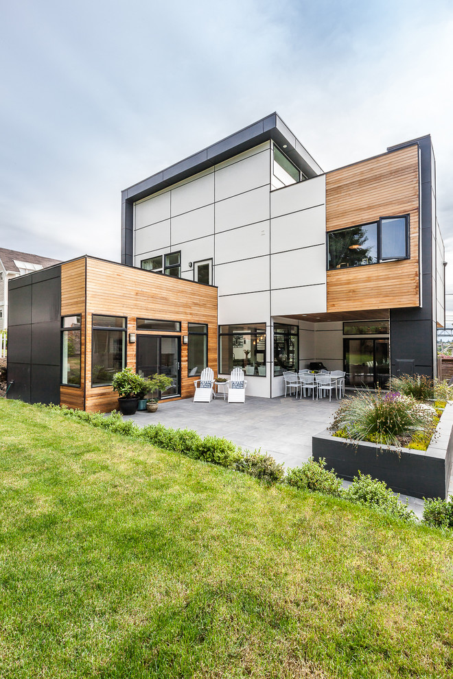 Photo of a large contemporary three-storey exterior in Seattle with mixed siding and a flat roof.