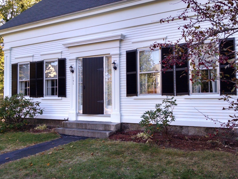 Mid-sized country two-storey white exterior in Portland Maine with wood siding.