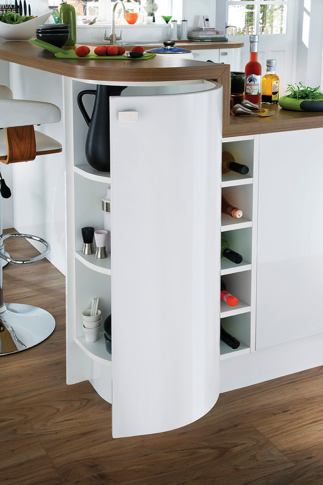 This is an example of a small contemporary u-shaped eat-in kitchen in Other with an integrated sink, flat-panel cabinets, white cabinets and white splashback.