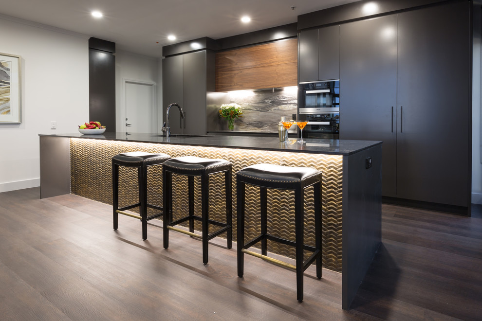 Photo of a large contemporary galley open plan kitchen in Auckland with flat-panel cabinets, black cabinets, quartz benchtops, multi-coloured splashback, stainless steel appliances and with island.