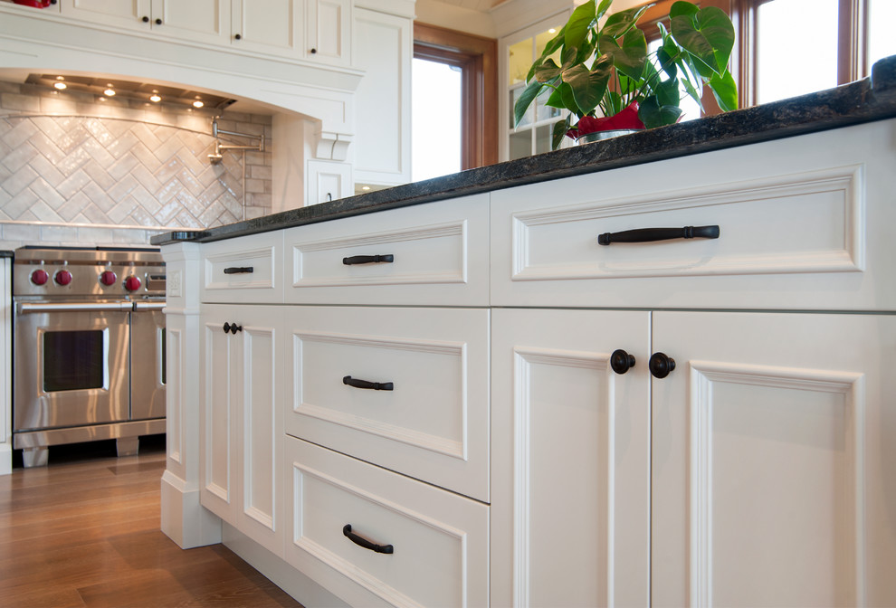 Photo of a traditional u-shaped eat-in kitchen in Vancouver with raised-panel cabinets and white cabinets.