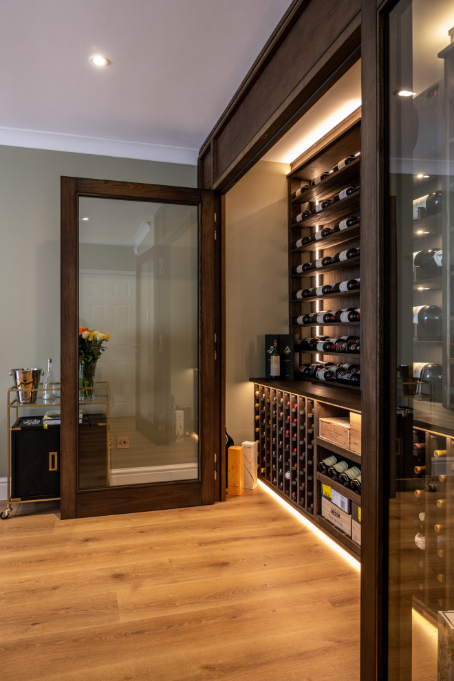 Mid-sized traditional wine cellar in Essex with display racks.