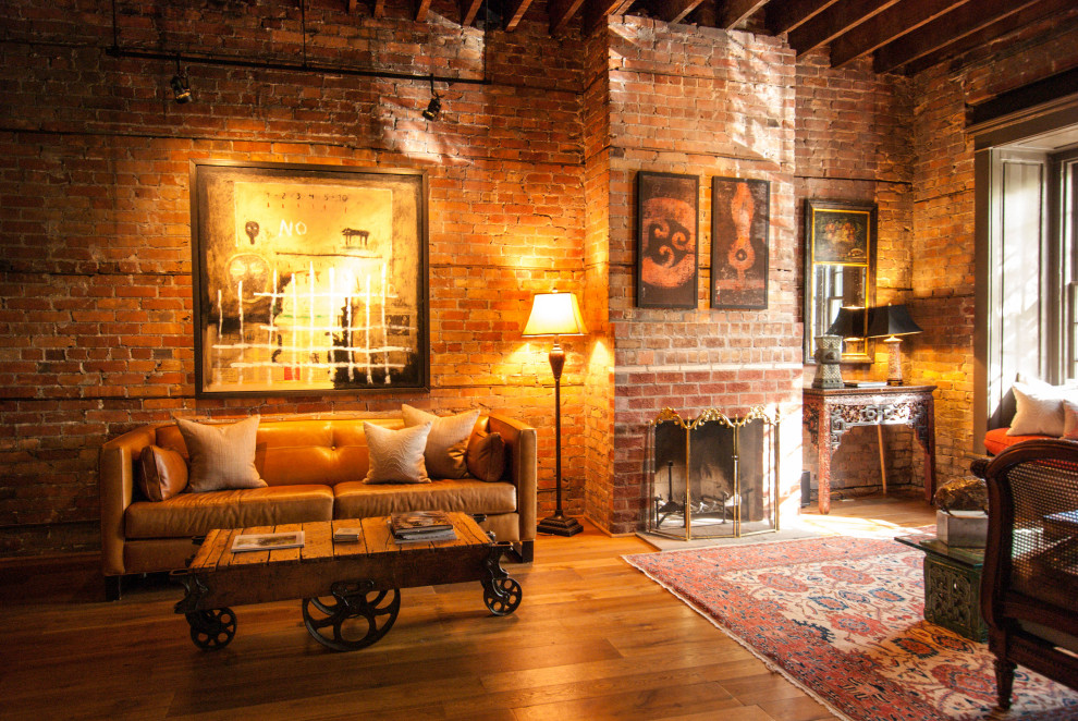 Mid-sized industrial formal enclosed living room in DC Metro with a brick fireplace surround, exposed beam and brick walls.