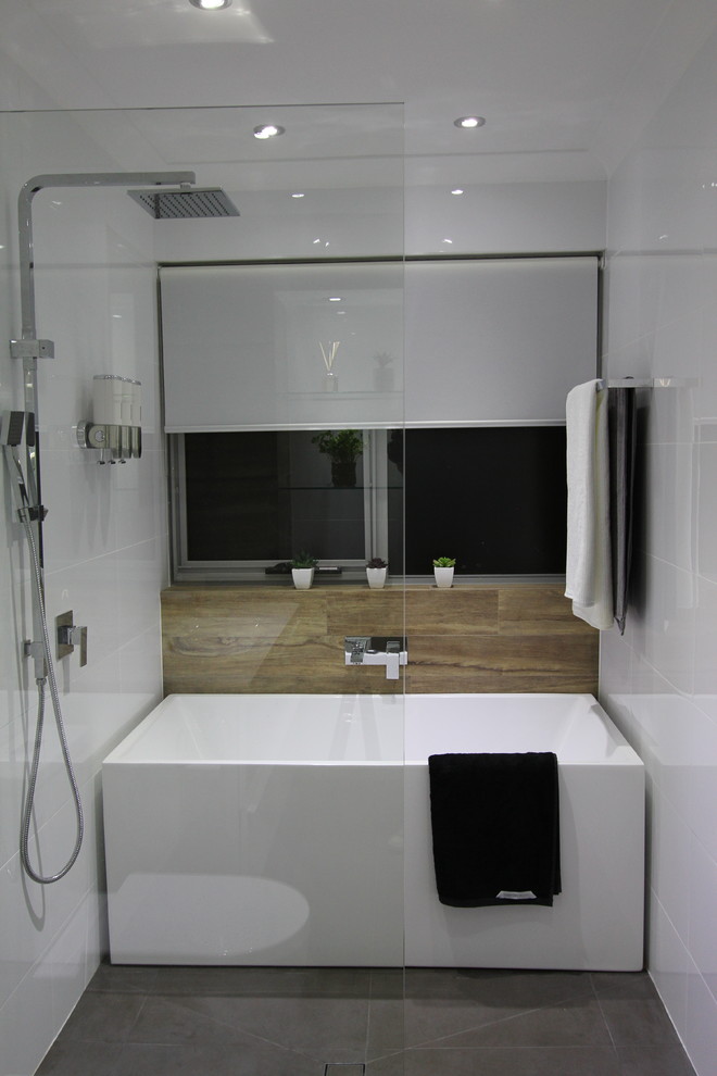 Design ideas for a mid-sized modern master bathroom in Perth with a wall-mount sink, white cabinets, a freestanding tub, an open shower, a one-piece toilet, gray tile, porcelain tile, white walls and porcelain floors.