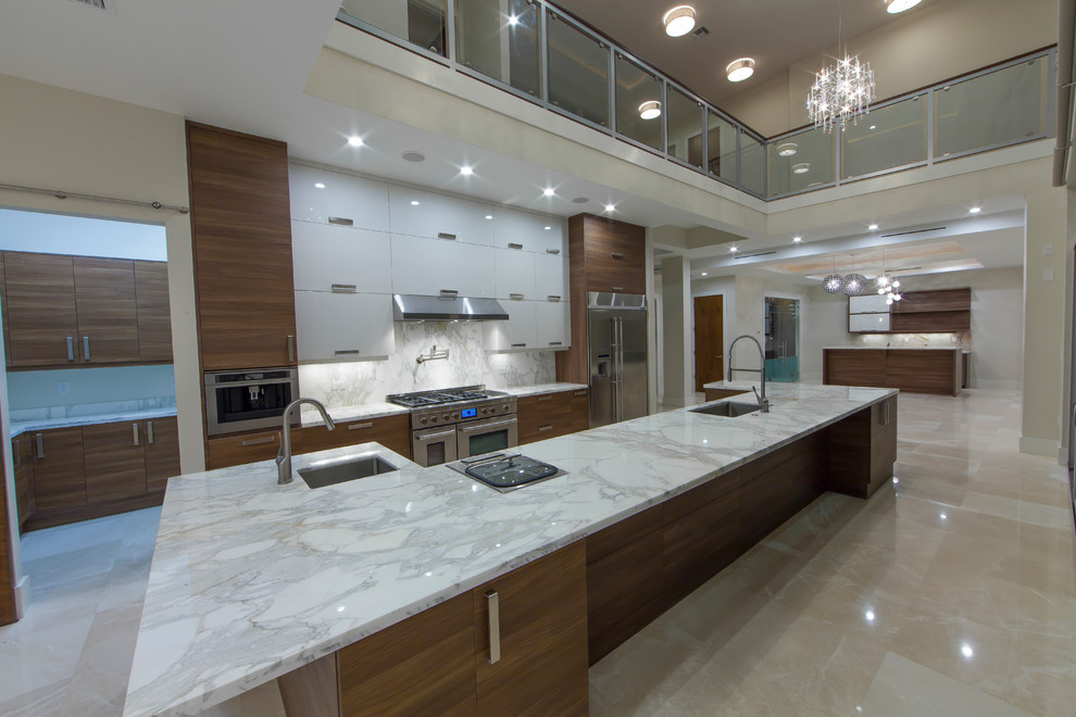 This is an example of a mid-sized modern galley eat-in kitchen in Miami with an undermount sink, flat-panel cabinets, medium wood cabinets, marble benchtops, white splashback, stone slab splashback, stainless steel appliances, marble floors and with island.
