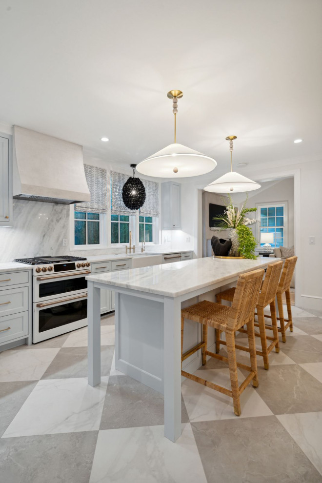 Photo of a beach style kitchen in Charleston with a farmhouse sink, beaded inset cabinets, blue cabinets, marble benchtops, white splashback, marble splashback, white appliances, porcelain floors, with island and white benchtop.