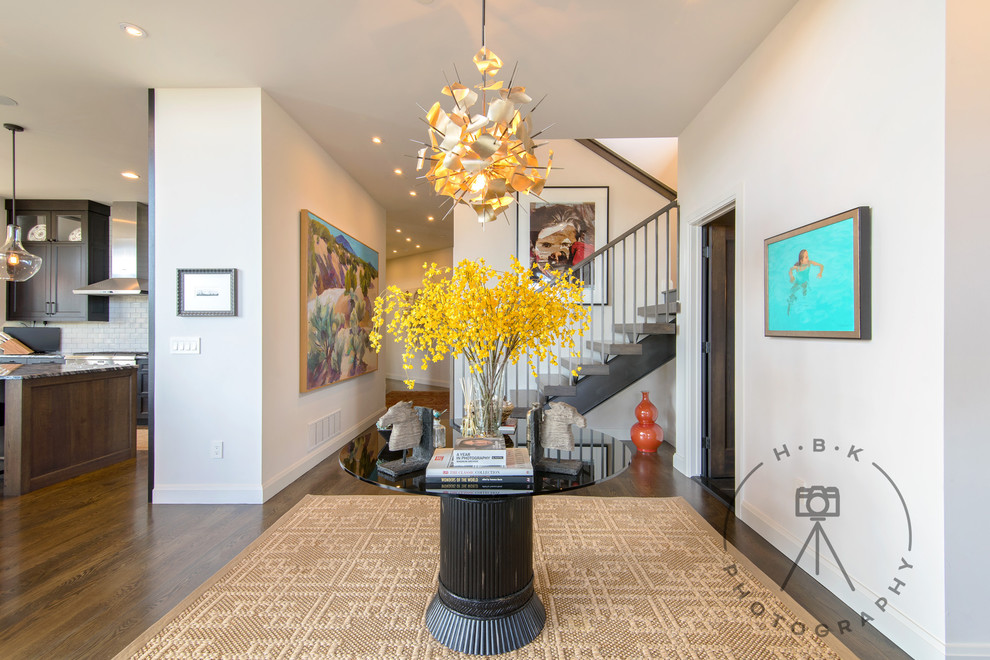 Large medium tone wood floor and brown floor foyer photo with white walls