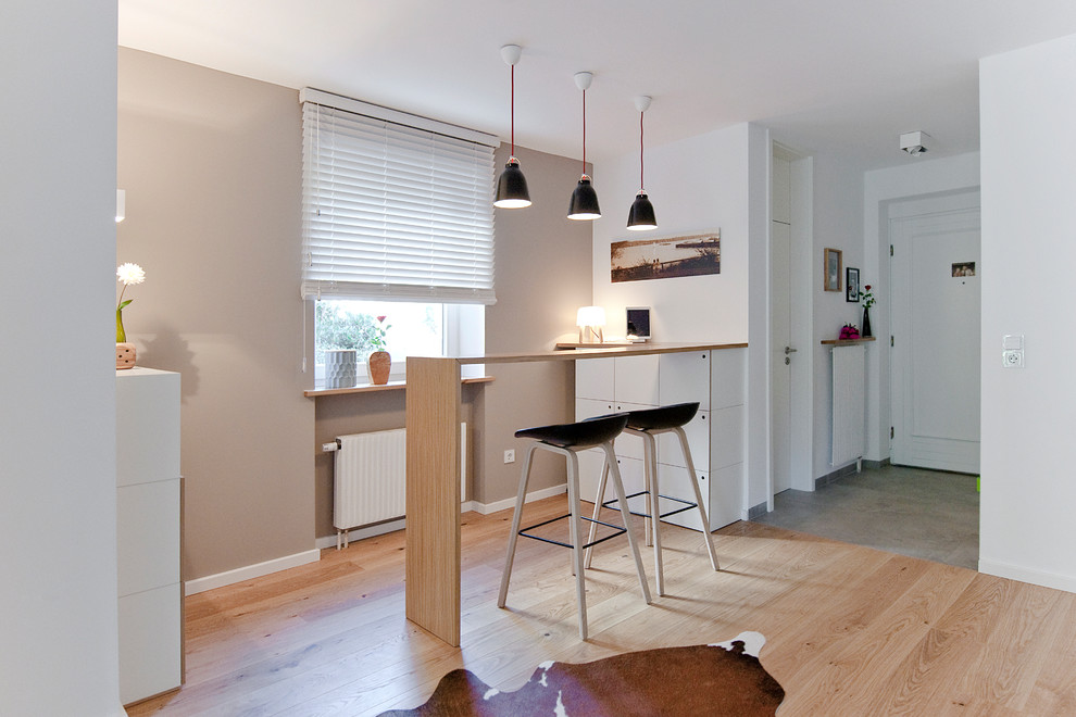 Mid-sized scandinavian single-wall open plan kitchen with brown floor, medium hardwood floors and a peninsula.