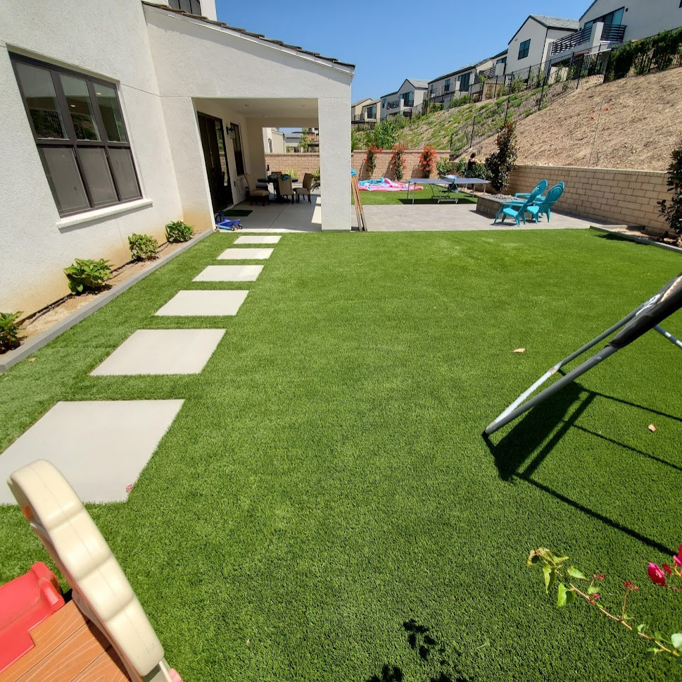 Idee per un ampio giardino minimalista esposto in pieno sole davanti casa in estate con pavimentazioni in cemento e recinzione in metallo