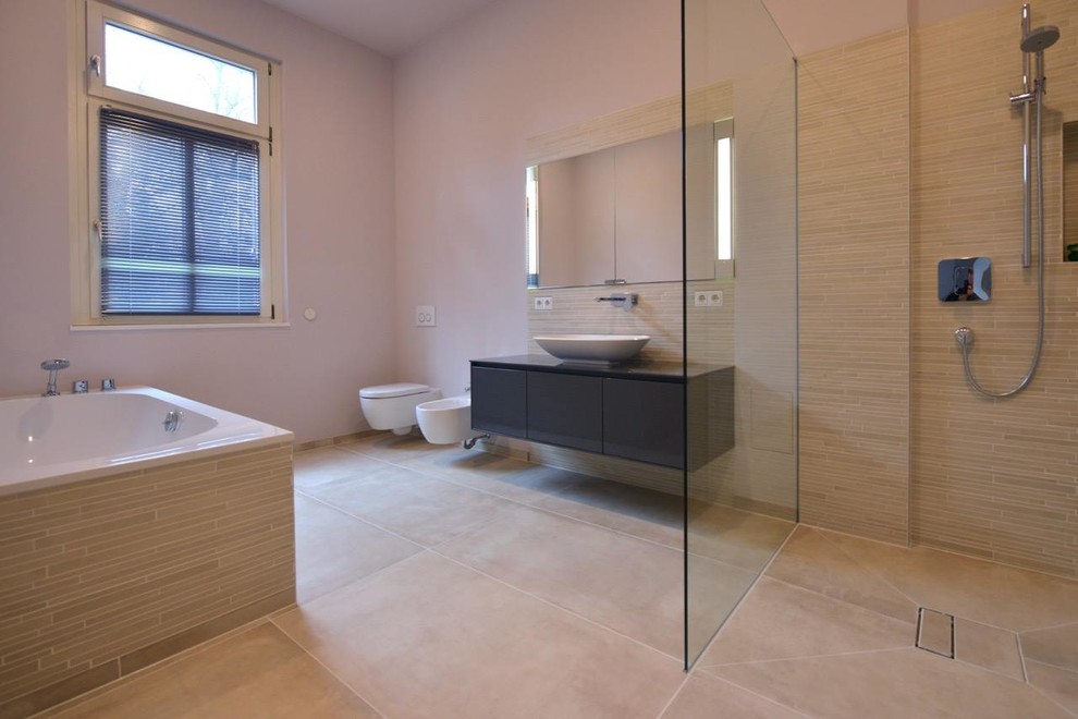 Large contemporary bathroom in Berlin with flat-panel cabinets, black cabinets, a curbless shower, a wall-mount toilet, beige tile, matchstick tile, a vessel sink and an open shower.