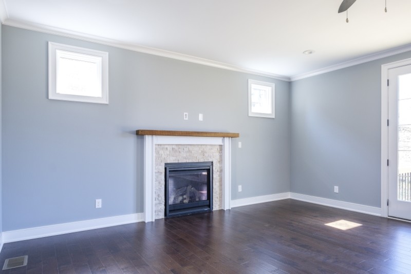 This is an example of a mid-sized transitional enclosed living room in Louisville with blue walls, vinyl floors, a standard fireplace, a stone fireplace surround and no tv.