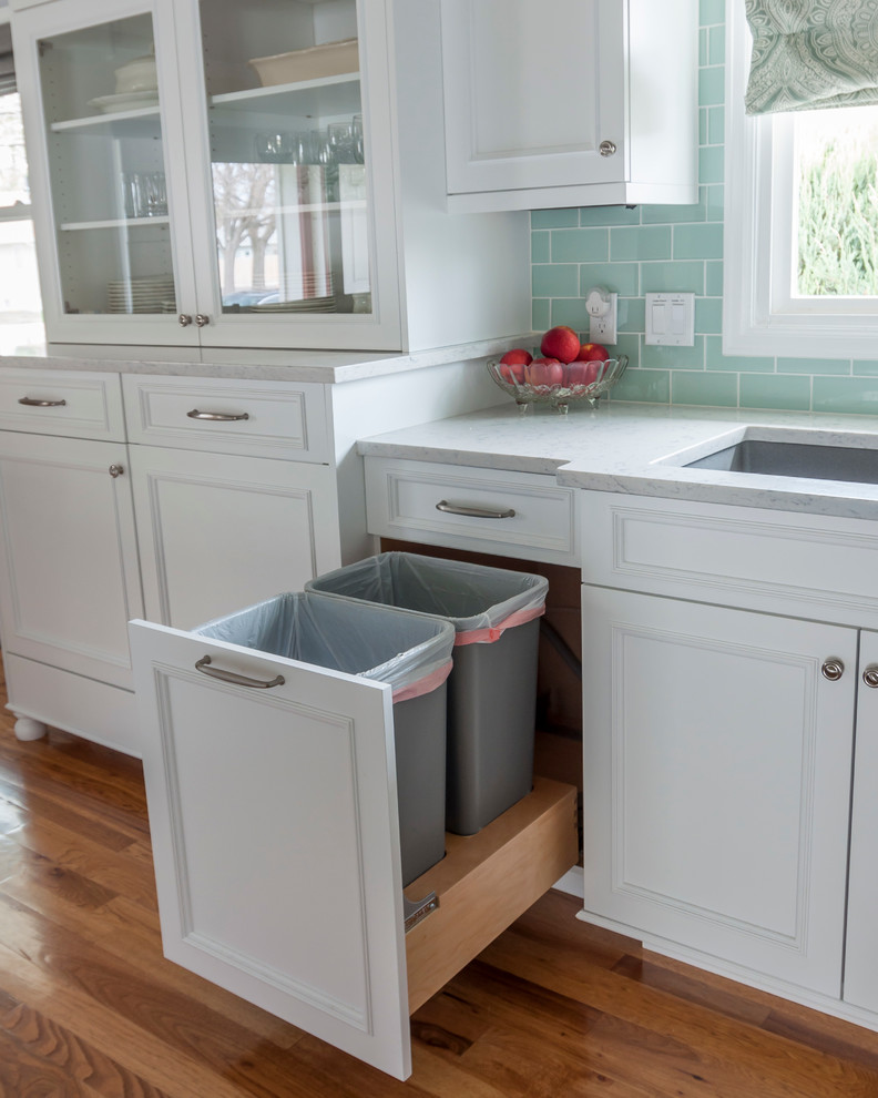 Example of a mid-sized transitional medium tone wood floor home design design in Denver with a single-bowl sink, flat-panel cabinets, yellow cabinets, quartz countertops, blue backsplash, glass tile backsplash, white appliances and an island
