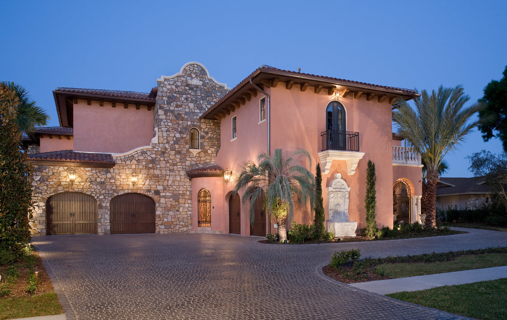 Inspiration for a large mediterranean two-storey stucco pink exterior in Orlando.