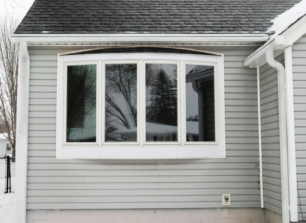 Aménagement d'une façade de maison grise rétro de taille moyenne et de plain-pied avec un toit en shingle et un toit gris.