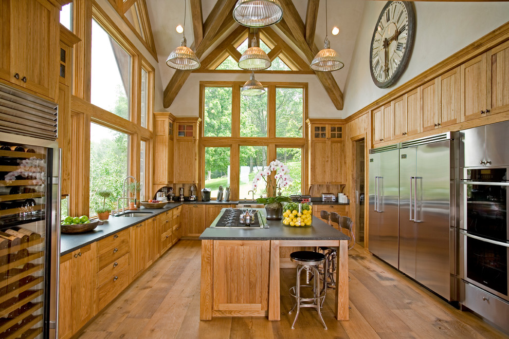 Inspiration for an expansive country u-shaped kitchen in New York with an undermount sink, shaker cabinets, medium wood cabinets, stainless steel appliances, medium hardwood floors, with island and onyx benchtops.