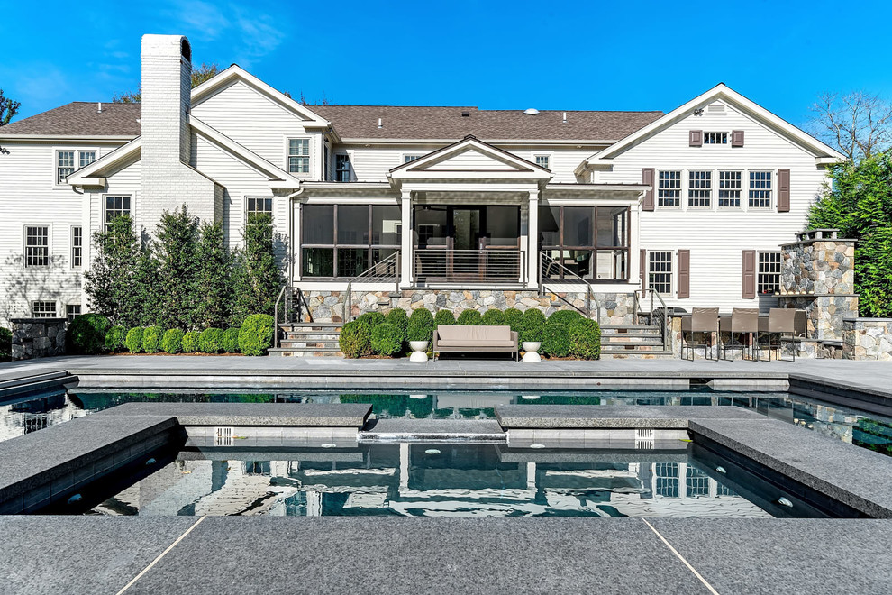 Example of a transitional backyard custom-shaped lap pool design in New York