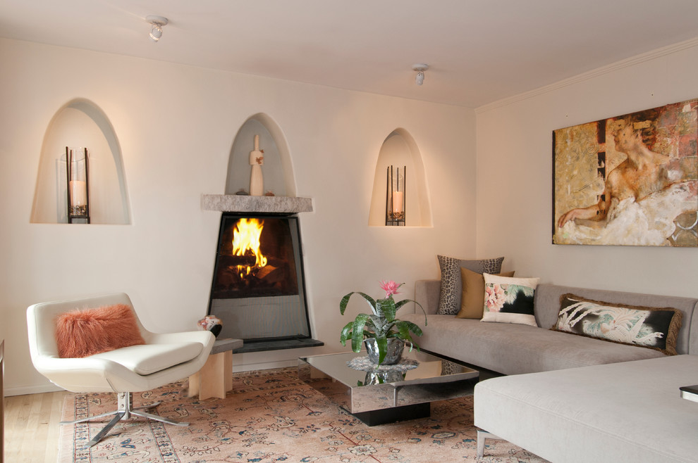 Large southwest formal and open concept light wood floor living room photo in Albuquerque with a standard fireplace, white walls, a plaster fireplace and a tv stand