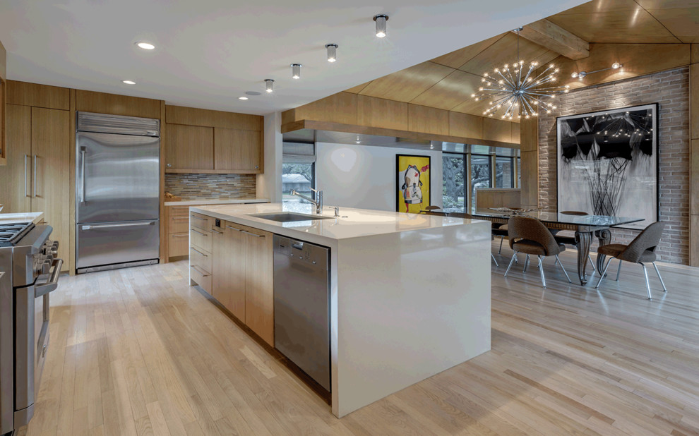 Design ideas for a mid-sized midcentury galley eat-in kitchen in Dallas with an undermount sink, flat-panel cabinets, light wood cabinets, quartz benchtops, beige splashback, glass tile splashback, stainless steel appliances, light hardwood floors, with island and white benchtop.