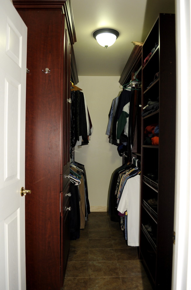 Photo of a mid-sized traditional gender-neutral walk-in wardrobe in Philadelphia with raised-panel cabinets and brown cabinets.