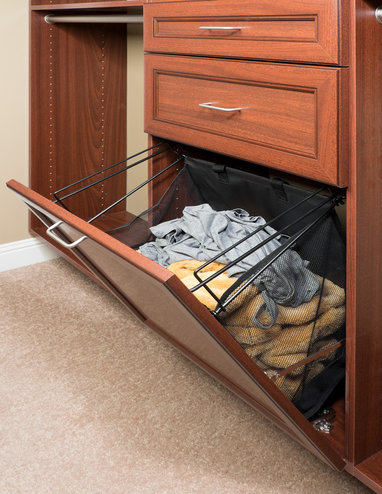Traditional gender-neutral walk-in wardrobe in Orange County with flat-panel cabinets, medium wood cabinets and carpet.