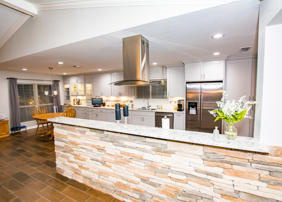Porcelain tile and brown floor kitchen photo in Austin with an undermount sink, shaker cabinets, gray cabinets, white backsplash, subway tile backsplash, stainless steel appliances, a peninsula and quartz countertops