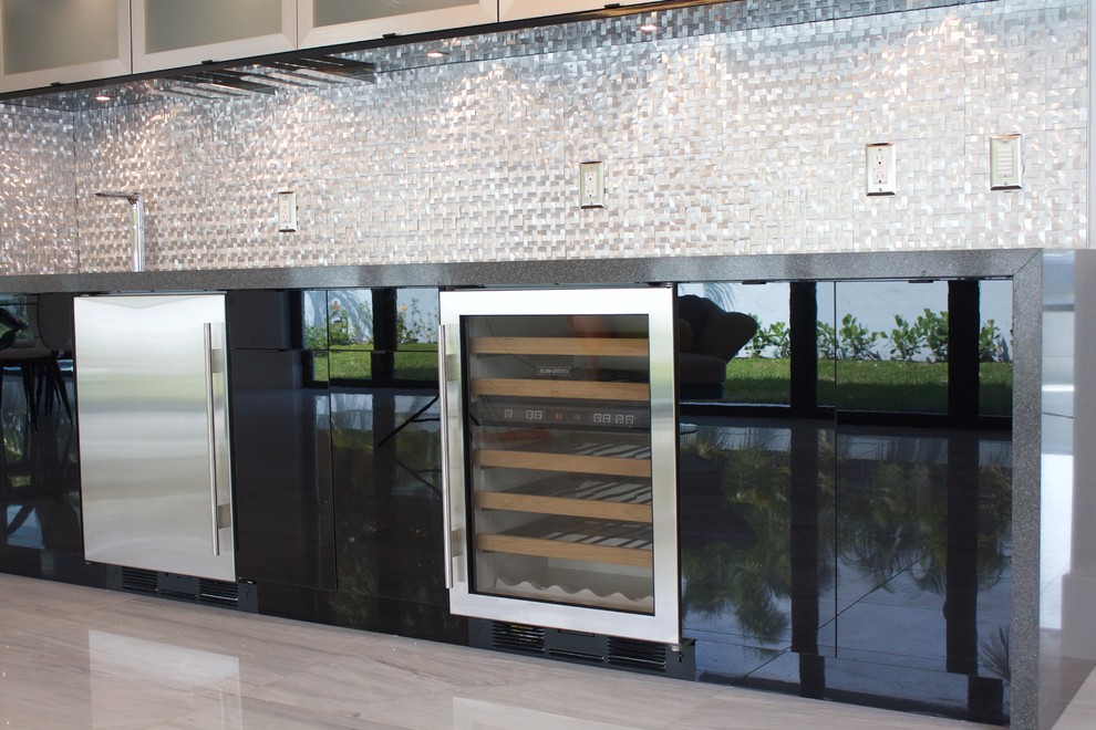This is an example of a contemporary single-wall wet bar in Miami with an undermount sink, flat-panel cabinets, black cabinets, quartz benchtops, grey splashback, metal splashback and marble floors.