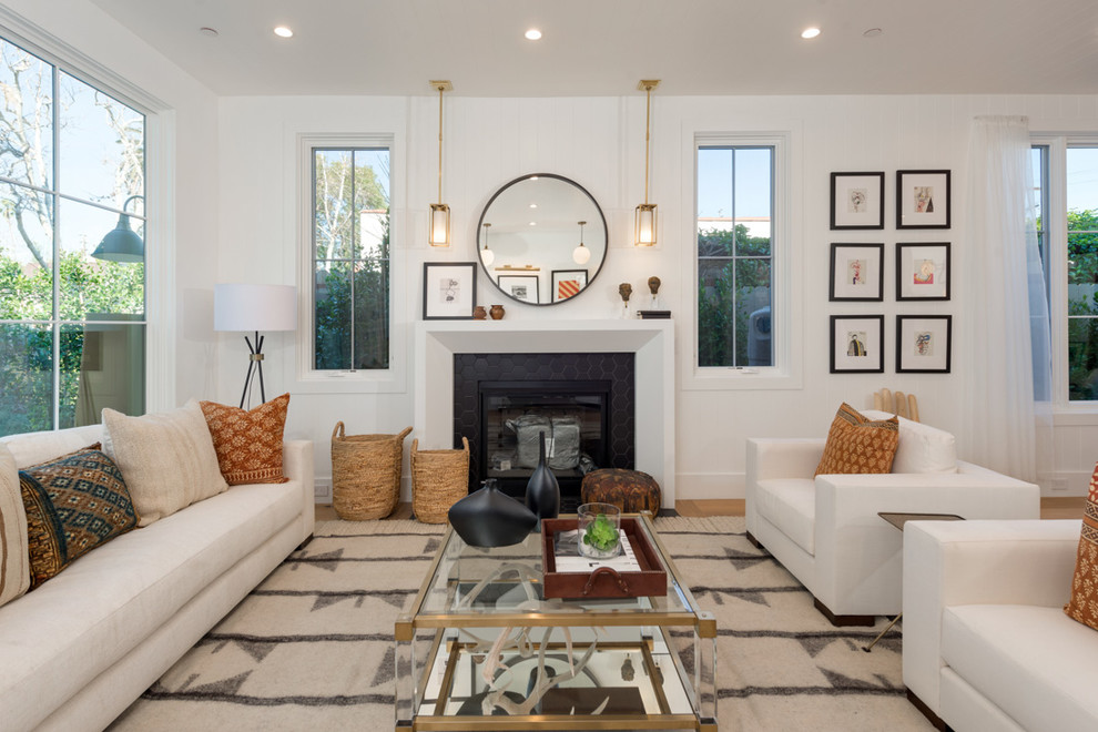 This is an example of a transitional formal living room in Los Angeles with white walls and a standard fireplace.