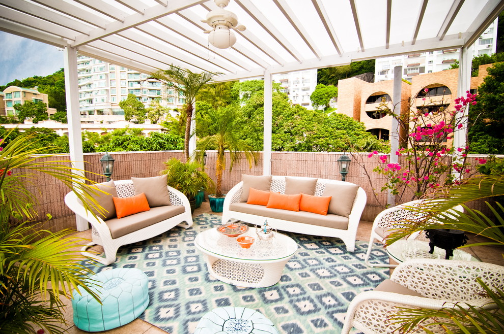 This is an example of a tropical patio in Nashville with a pergola.