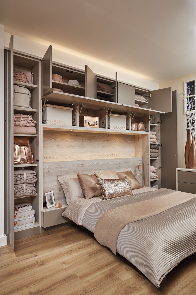 Design ideas for a mid-sized contemporary master bedroom in London with beige walls and brown floor.