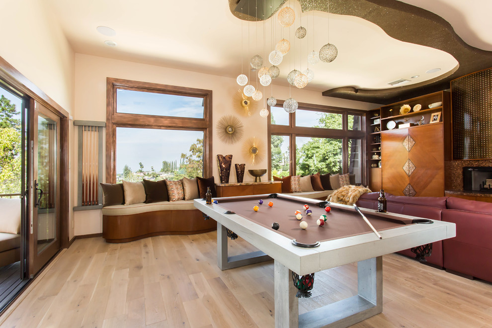 This is an example of an expansive eclectic loft-style family room in Los Angeles with beige walls, light hardwood floors, a standard fireplace and a tile fireplace surround.