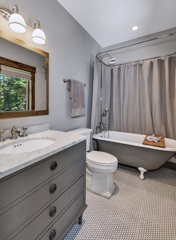 Inspiration for a small country kids bathroom in Other with furniture-like cabinets, grey cabinets, a claw-foot tub, a shower/bathtub combo, a one-piece toilet, gray tile, grey walls, mosaic tile floors, an undermount sink, granite benchtops, white floor, a shower curtain and grey benchtops.