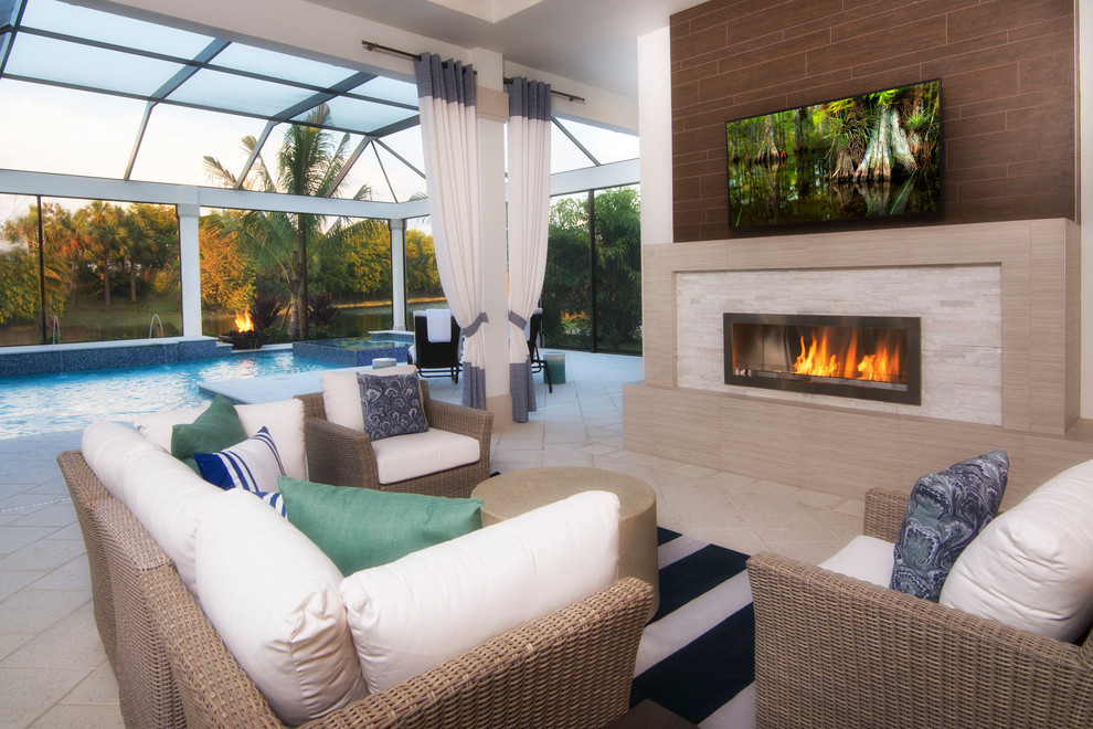 Beach style backyard patio in Miami with tile and with fireplace.