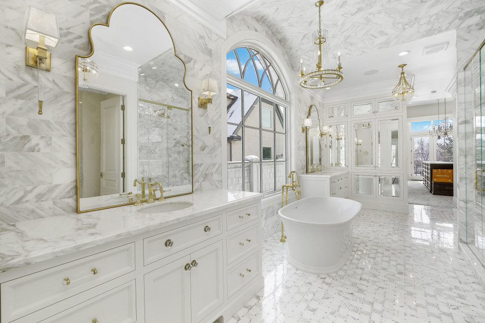 Пример оригинального дизайна: огромная главная ванная комната со стиральной машиной в классическом стиле с фасадами с утопленной филенкой, белыми фасадами, отдельно стоящей ванной, открытым душем, унитазом-моноблоком, серой плиткой, мраморной плиткой, белыми стенами, мраморным полом, врезной раковиной, мраморной столешницей, серым полом, душем с распашными дверями, белой столешницей, тумбой под две раковины и встроенной тумбой