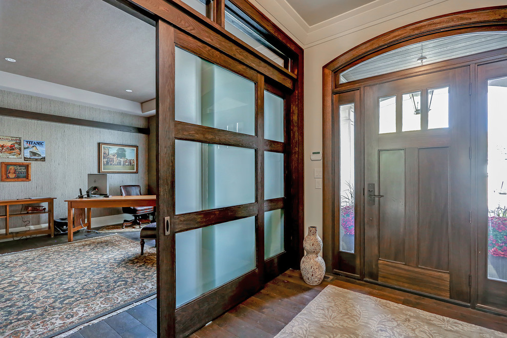 Foyer - mid-sized transitional medium tone wood floor and brown floor foyer idea in Toronto with white walls and a dark wood front door