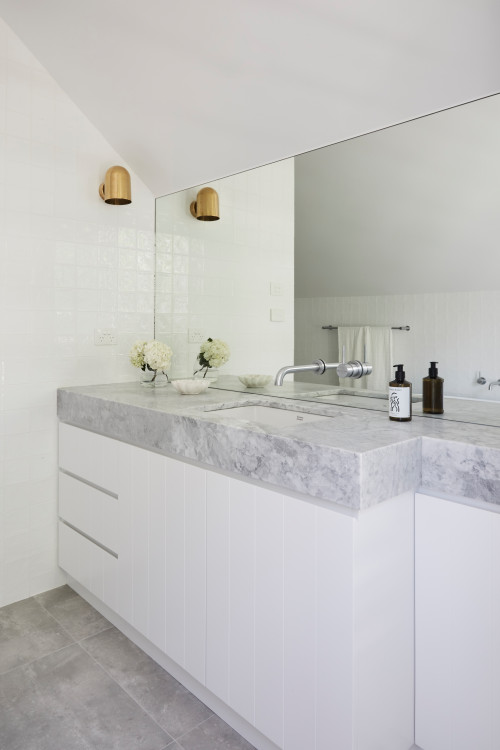 Monochromatic Glamour: White Vanity and Brass Wall Sconce
